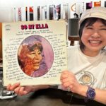 ジャズのレコードを持って笑顔でほほ笑むオーナー