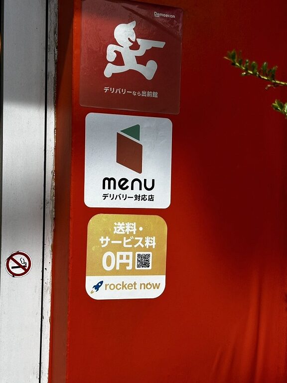 お店のドアに貼られたデリバリー業者のステッカー